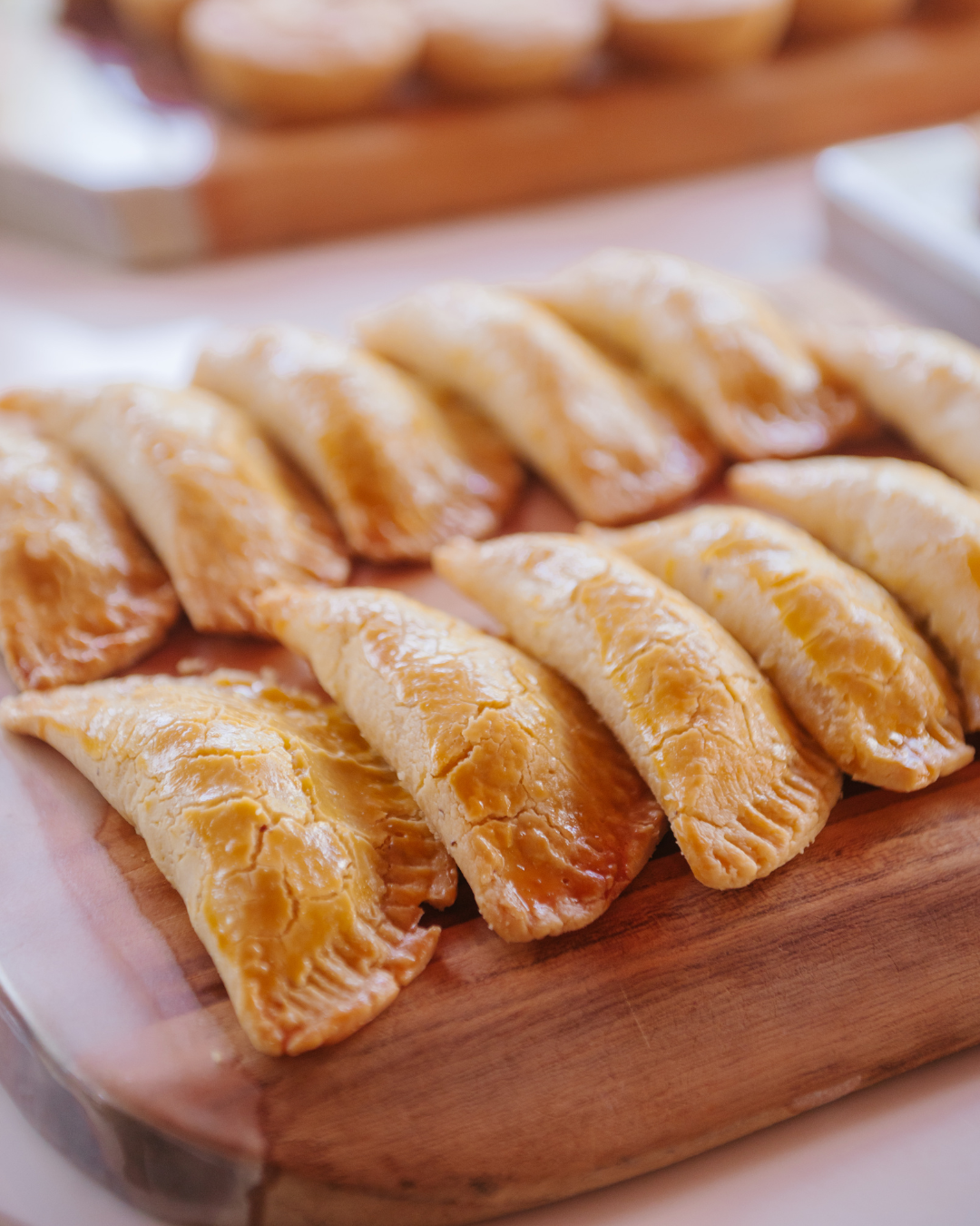 Empanadas douradas servidas em tábua de madeira