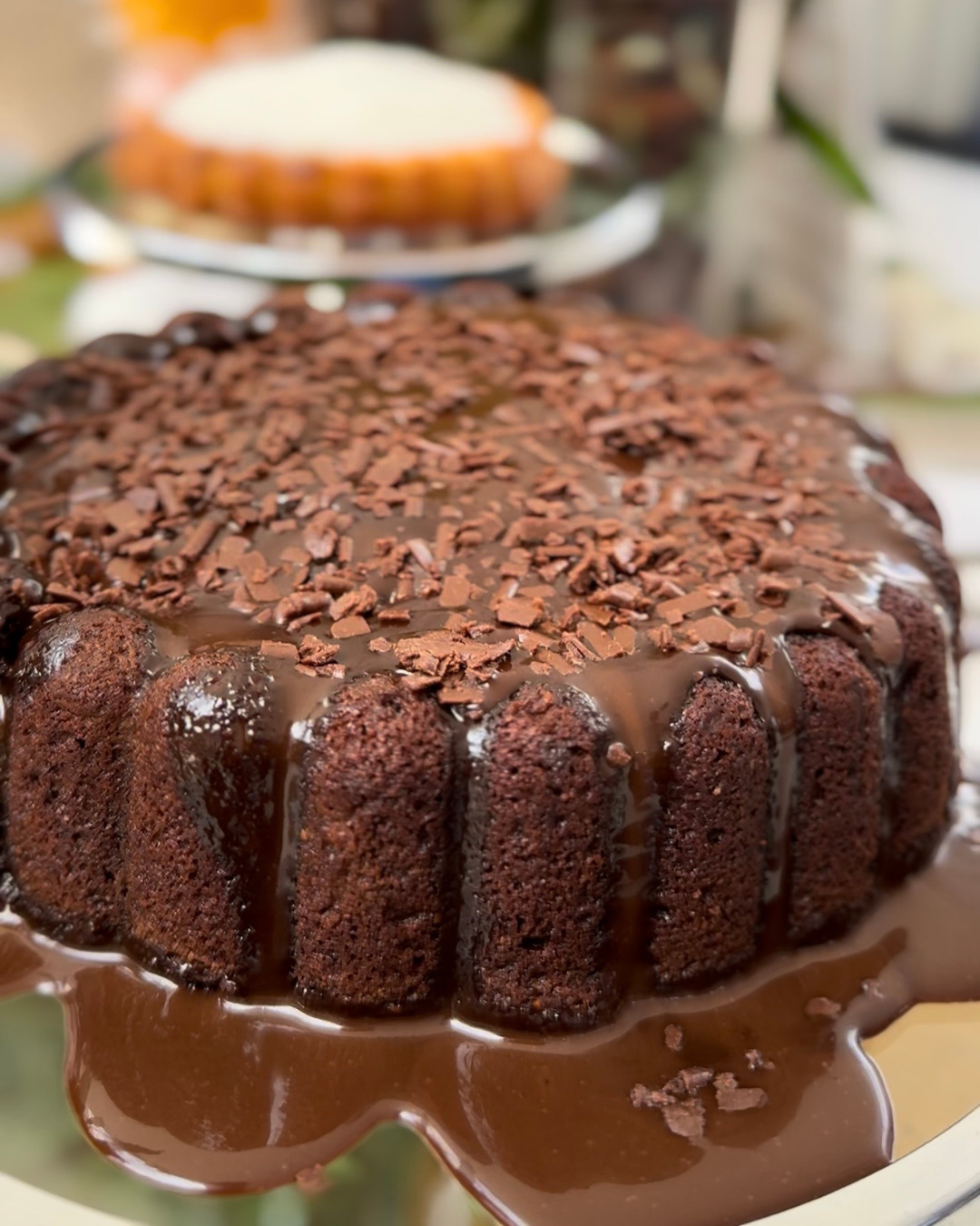 Bolo de chocolate com cobertura cremosa e raspas de chocolate