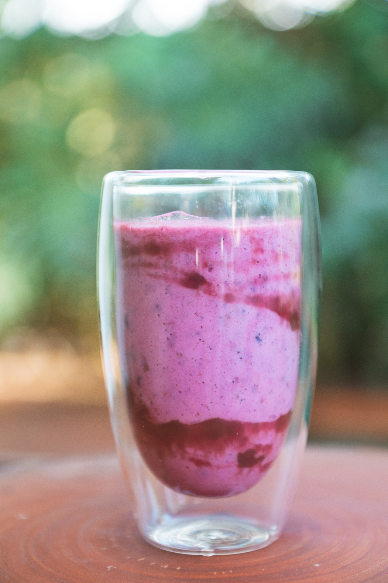 Smoothie de frutas vermelhas servido em copo de vidro duplo